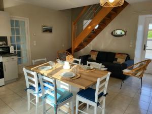 cocina y comedor con mesa de madera y sillas en Gîte les Embruns, en Pirou