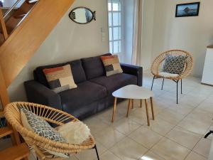 sala de estar con sofá y 2 sillas en Gîte les Embruns, en Pirou