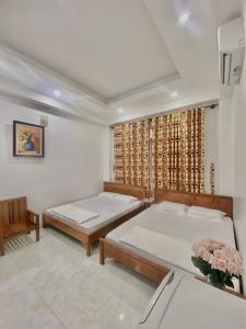 1 Schlafzimmer mit 2 Betten und einem Fenster in der Unterkunft Hà Tiên Hạnh Phúc Hotel in Hà Tiên