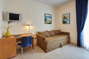 een woonkamer met een bank en een bureau bij Costa del Salento - CDSHotels in Lido Marini