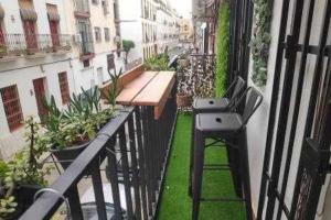 een balkon met een tafel en een bank op een gebouw bij Alameda 2 Dormitorios in Sevilla