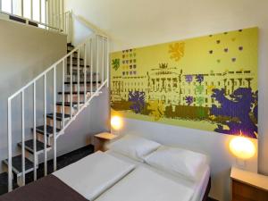 ein kleines Zimmer mit einem Bett und einer Treppe in der Unterkunft B&B Hotel Braunschweig-Nord in Braunschweig