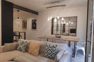 een woonkamer met een bank en een eetkamer bij Alameda 2 Dormitorios in Sevilla