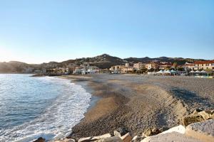 einen Strand mit Felsen und Häusern und dem Meer in der Unterkunft Il Gabbiano in Albissola Marina