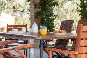 una mesa de madera con un plato de comida y zumo de naranja en Santolina - Casa Rural en l'Ampolla con piscina privada, jardín y barbacoa - Deltavacaciones, en L'Ampolla