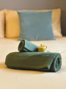 瓦萊塔的住宿－Valletta Boutique Home，床上的绿色滚动毛巾
