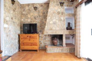 ein Wohnzimmer mit einem TV und einem Kamin in der Unterkunft Mistral - Adosado en l'Ampolla con acceso directo al mar - Deltavacaciones in L'Ampolla