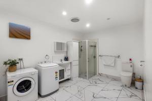 a bathroom with a washing machine and a washer at Spacious Sandy Bay Apartment in Sandy Bay
