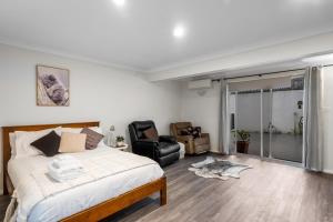 a bedroom with a bed and a chair and a window at Spacious Sandy Bay Apartment in Sandy Bay