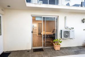 a sliding glass door to a bedroom with a bed at Spacious Sandy Bay Apartment in Sandy Bay