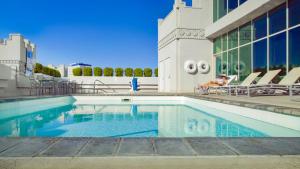 una mujer sentada en una silla junto a una piscina en The Commerce Casino & Hotel en Commerce