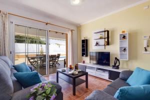 a living room with a couch and a tv and a table at Villa Maria Del Mar by Villa Plus in Cala'n Porter