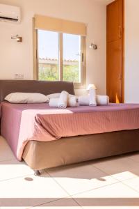 a bedroom with a large bed with two stuffed animals on it at Villa Shanta in Peyia