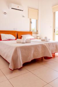 a large bed with two pillows on it in a room at Villa Shanta in Peyia
