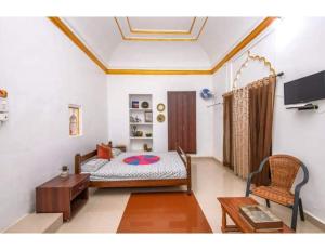 にあるKila The Heritage Palace, Kothiのベッドルーム(ベッド1台、テーブル、テレビ付)