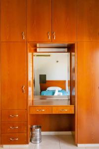 Schlafzimmer mit einem Spiegel in einem Holzschrank in der Unterkunft Villa Shanta in Peyia