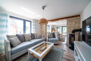 a living room with a couch and a table at Ferienhaus Landlust - Erholung mit Fasssauna und Whirlpool nahe Binz! in Zirkow