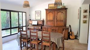 una sala da pranzo con tavolo, scrivania e chitarra di Chambre d'hôte BB proche d'Aix en Provence a Éguilles