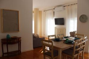 une table à manger avec des chaises et une horloge murale dans l'établissement la Bohème Peschiera luxury apartment, à Peschiera del Garda