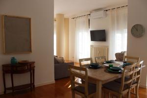 Una mesa de comedor con sillas y un reloj en la pared. en la Bohème Peschiera luxury apartment, en Peschiera del Garda