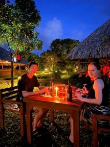 a man and woman sitting at a picnic table at night at Saffron Lake Yala in Tissamaharama