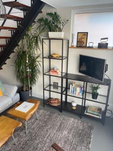 a living room with a black book shelf with a tv at Willem de Zwijgerlaan Luxury Ark in Amsterdam