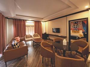 a hotel room with a living area and a bedroom at The Vibe By Ambiance in Murree
