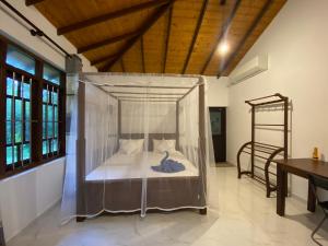 a bedroom with a bed with mosquito net at See Turtle Villa in Tangalle