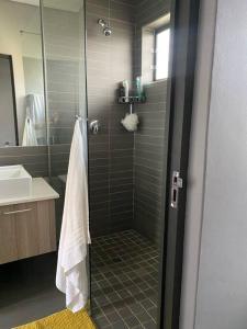 a bathroom with a shower with a glass door at The Blues in Pretoria