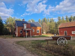 a barn with a bench in front of a house at Ferienhaus am Waldrand in Lillhärdal