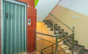 uma escada num edifício com uma porta verde em Flagship Sri Hari Premium Comforts Near Sandhya Digital 4K Theatre em Bangalore