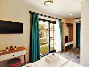 a room with a bed and a tv and a window at JULİETOTEL in Alaçatı