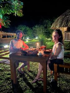 two women sitting at a picnic table at night at Saffron Lake Yala in Tissamaharama