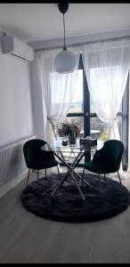 ein Wohnzimmer mit 2 Stühlen, einem Tisch und einem großen Fenster in der Unterkunft SUPER MIA PLUS!!! in Bukarest