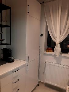 eine Küche mit weißen Schränken und einem Fenster in der Unterkunft SUPER MIA PLUS!!! in Bukarest