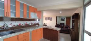 uma cozinha com armários laranja e um lavatório em INTI SUMAQ WASI em Cusco