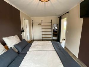 un grande letto in una stanza con una scala di Ferienwohnung „Klüterkamer“ - Hof Mühlenkoppel a Hasselberg