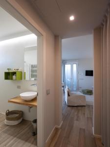 een badkamer met een wastafel en een kamer met een bed bij Agriturismo Terre degli Angeli in Pietra Ligure