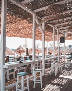 a restaurant with white tables and chairs on the beach at Paradise Beach Resort in Paradise Beach