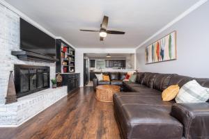 uma sala de estar com um sofá de couro e uma lareira em Colleens Corner Captivating 4bed 2.5 bath in Charming Neighborhood em Little Rock