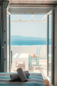 a room with a bed and a table and a view of the ocean at Paradise Beach Resort in Paradise Beach