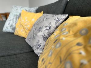 a couch with several pillows on it at 194, Belle Aire, Hemsby - Two bed recently renovated chalet, sleeps 4, pet friendly, free Wi-Fi and bed linen and towels included in Hemsby