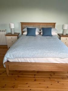 1 dormitorio con 1 cama con almohadas azules y 2 lámparas en Monterno, Luxury Accommodation Glengarriff, County Cork - Sleeps 8, en Glengarriff