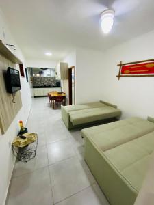 a living room with two couches and a television at Apartamento em Ubatuba - Condomínio Ville II - 300 metros da Praia do Sapê - Maranduba in Ubatuba