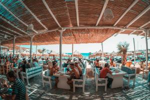 um grupo de pessoas sentadas em mesas na praia em Paradise Beach Resort em Paradise Beach