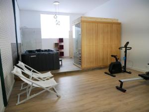 a room with two chairs and a treadmill and a gym at Clos de la Providence Chambres d'hôtes, piscine et Spa in Nolay