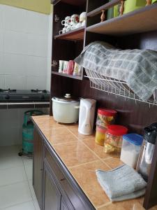 a kitchen with a counter top with food on it at Desa Kemboja Homestay in Pantai Cenang