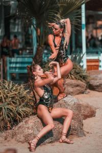 two women in bathing suits sitting on a rock at Paradise Beach Resort in Paradise Beach
