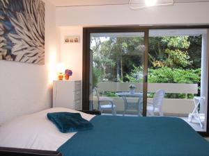 - une chambre avec un lit et un balcon avec une table dans l'établissement Apartment La Pomme de Pin by Interhome, à La Baule-les-Pins