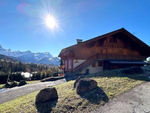 a building on a hill with rocks in front of it at Apartment La-Ina by Interhome in Chesières